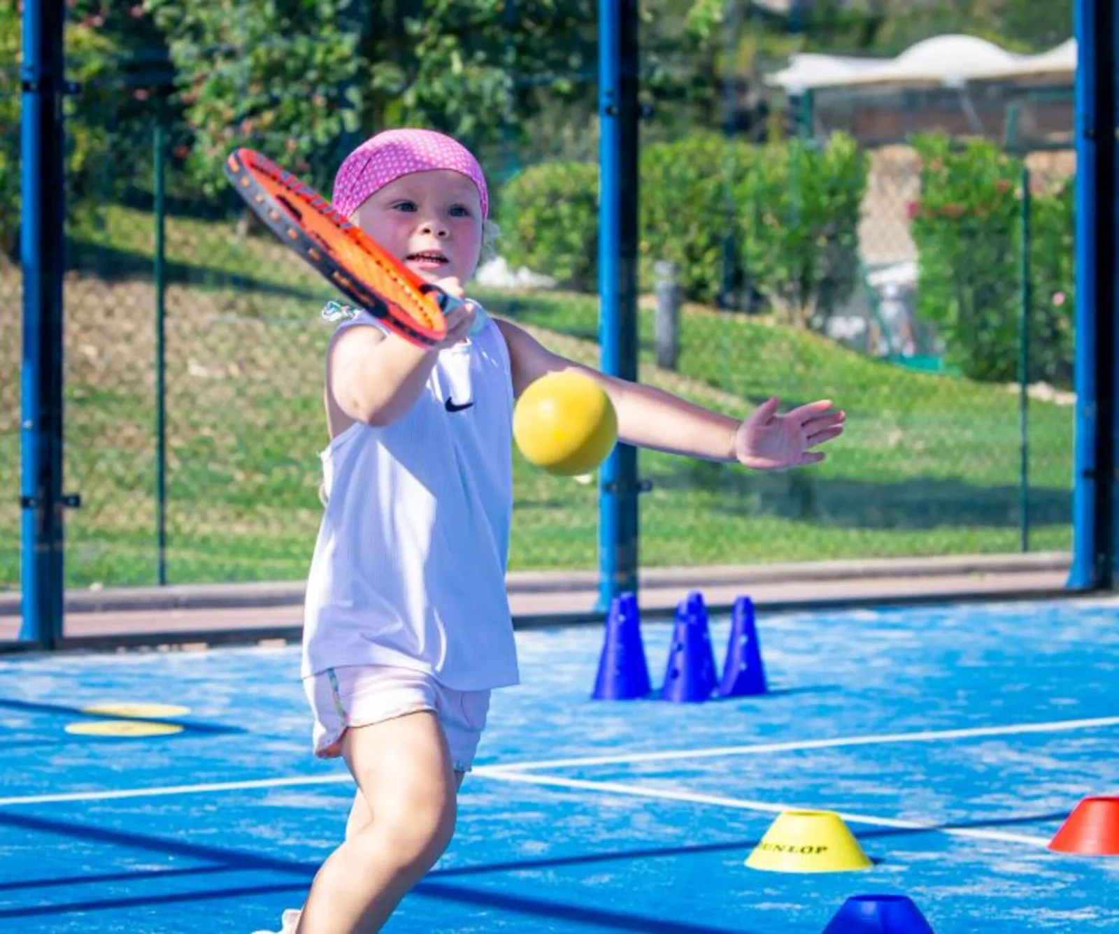 Niño sosteniendo una pelota de tenis de espuma en la pista