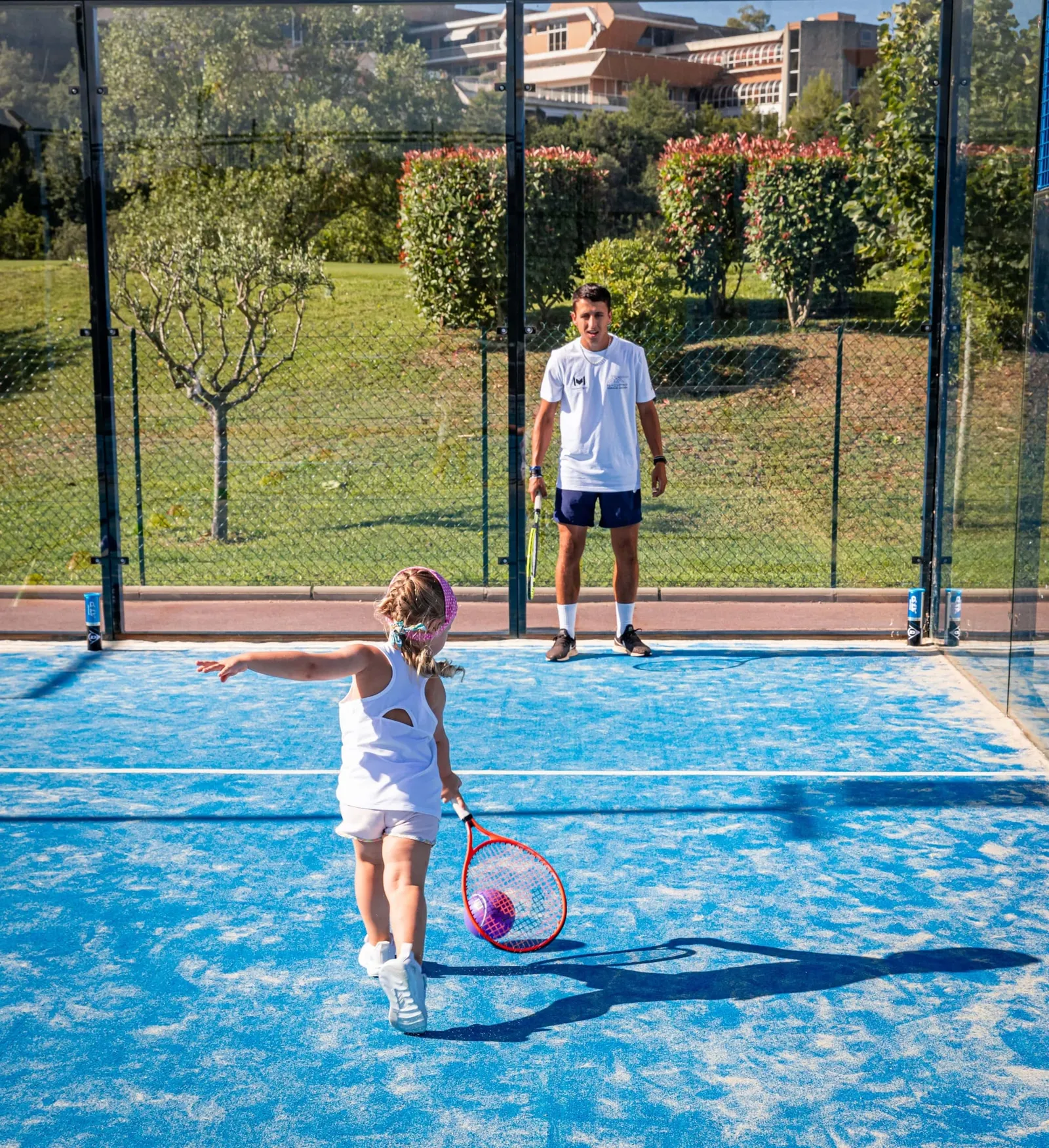 Niño sosteniendo una pelota de espuma y una raqueta junior