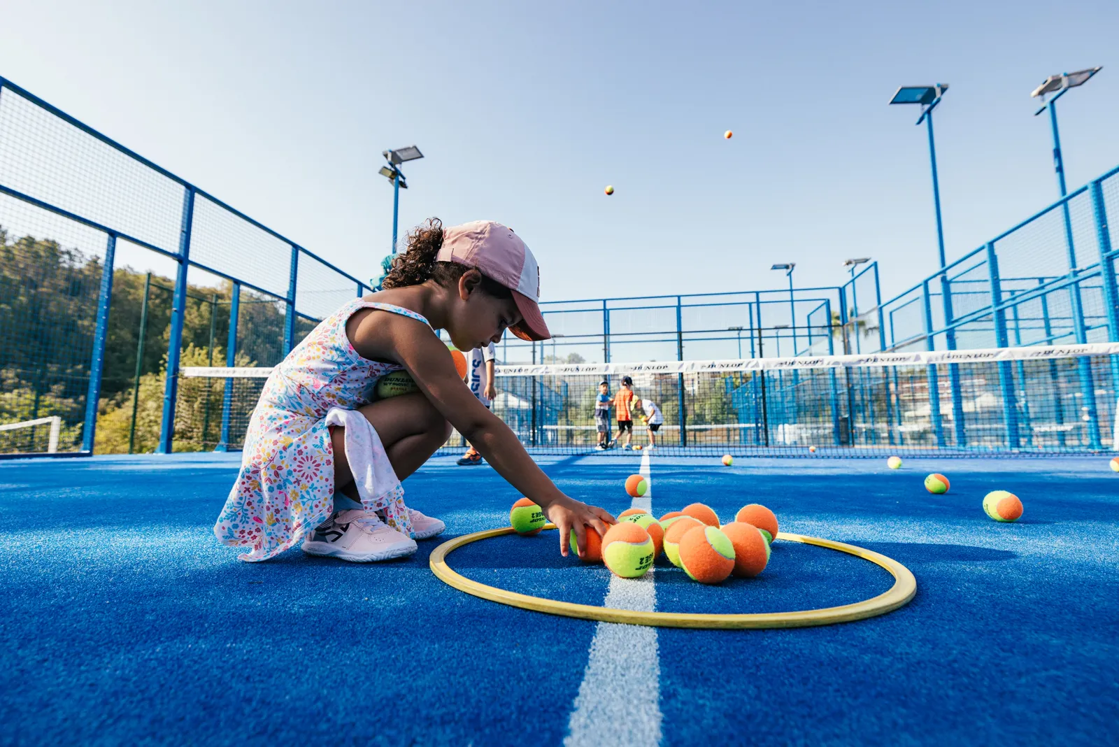 Child playing with a mini tennis ball on court