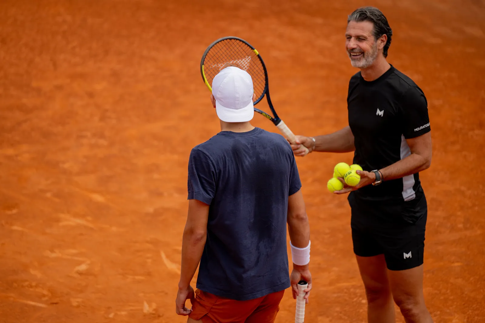 Patrick Mouratoglou on court with tennis balls