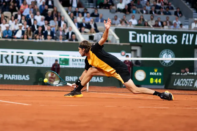 Joueur en pleine extension sur terre battue pour rattraper une balle