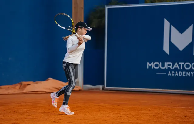 Player hitting a two-handed backhand on a clay court
