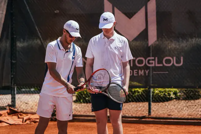Mouratoglou Academy coach adjusting a player’s racquet grip