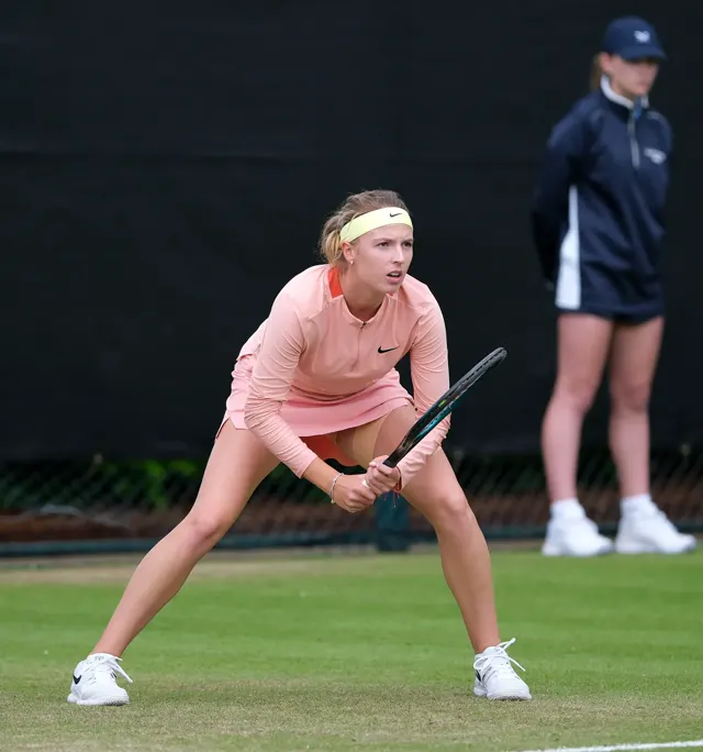 Female player in the ready position waiting to return serve on grass