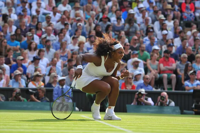 Tennis match on a grass court in front of packed stands