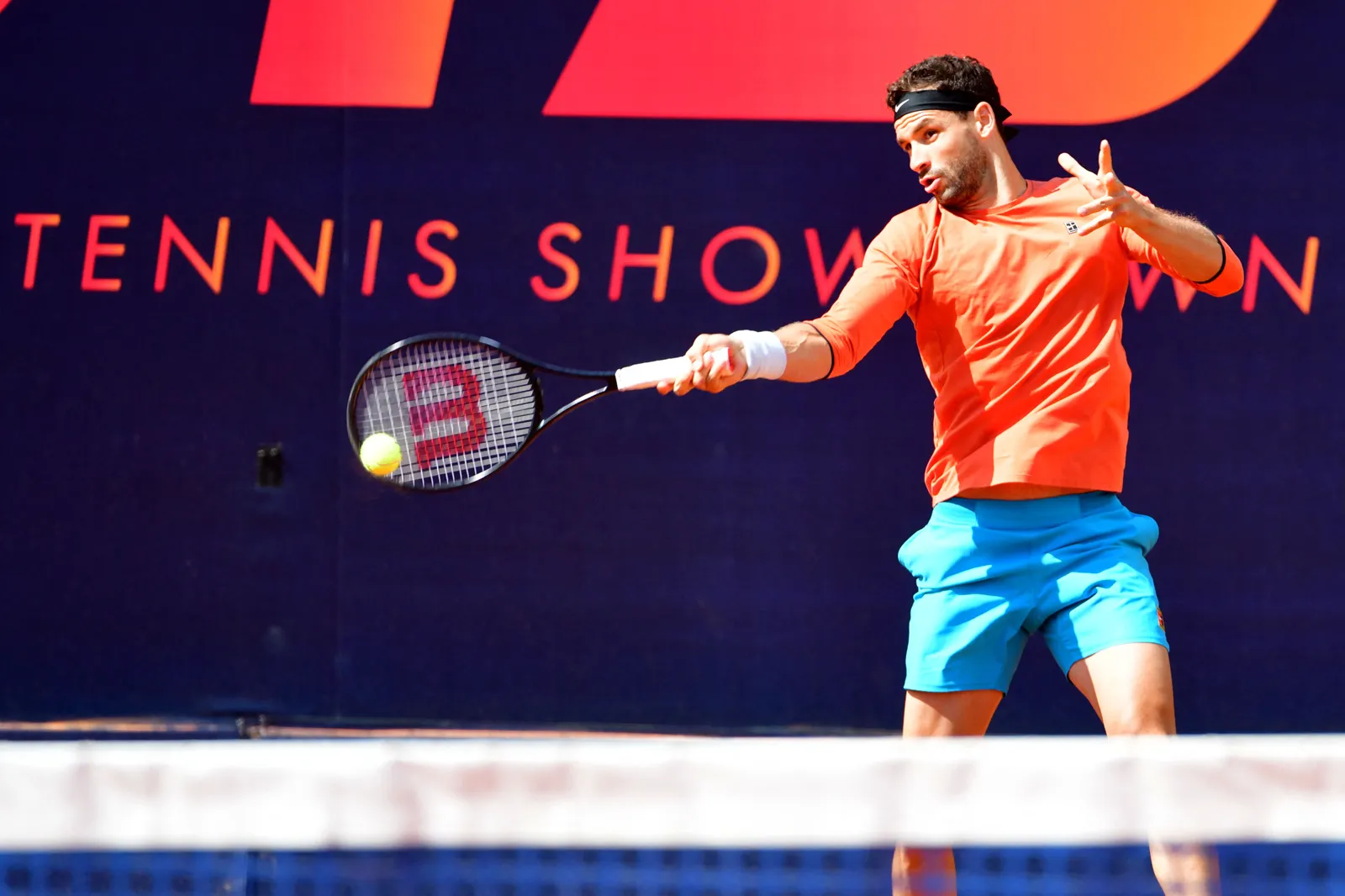 Joueur professionnel frappant un coup droit pendant un match d’exhibition