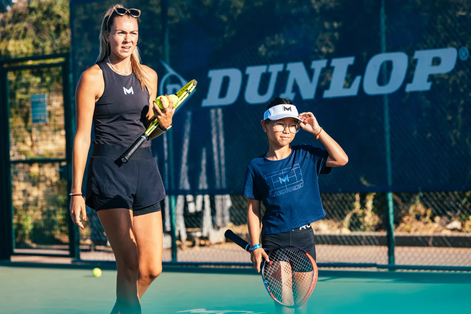 Coach de la Mouratoglou Academy avec un jeune joueur sur le court