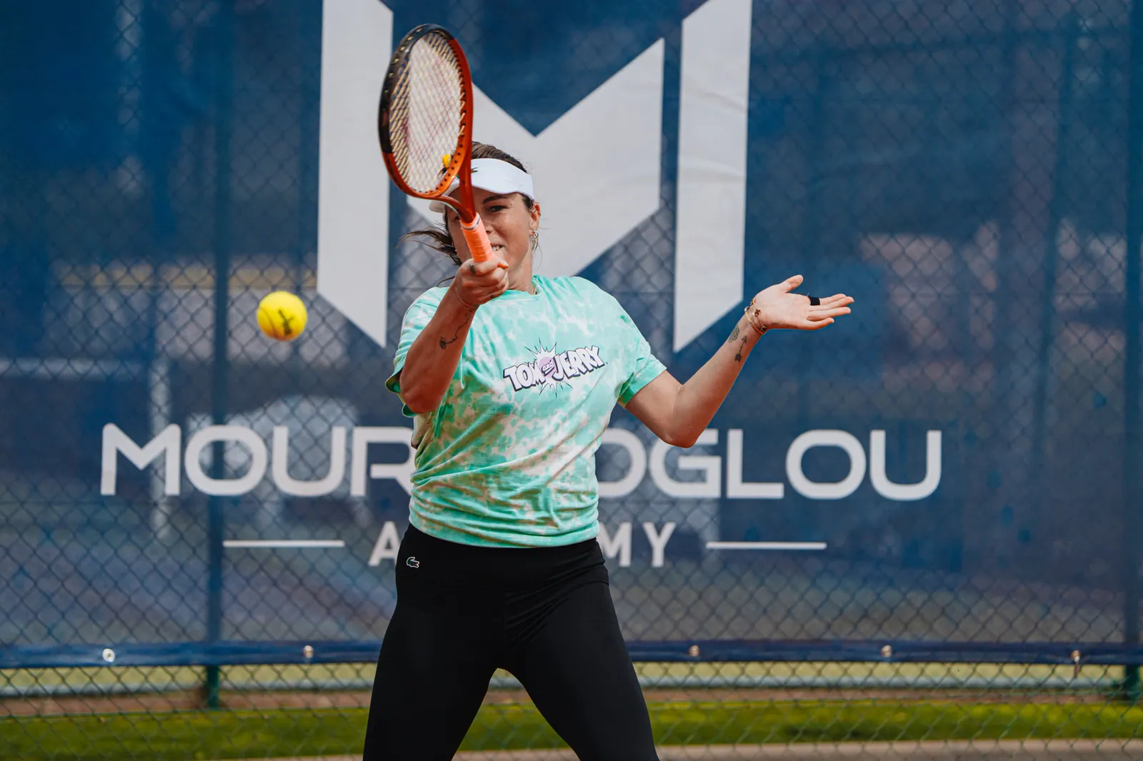 Player hitting a forehand on a Mouratoglou Academy court