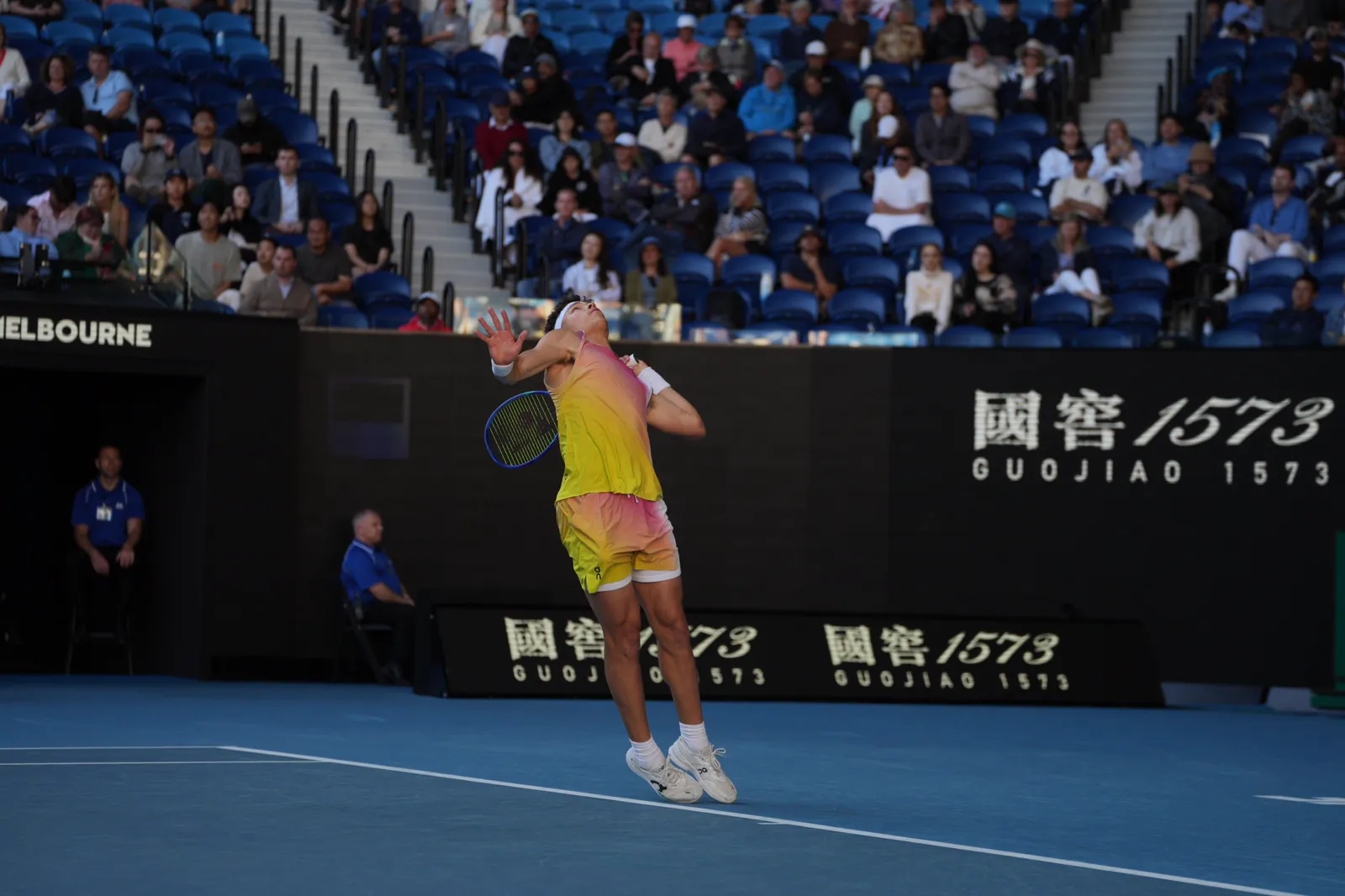 Joueuse au service sur un court dur dans un stade