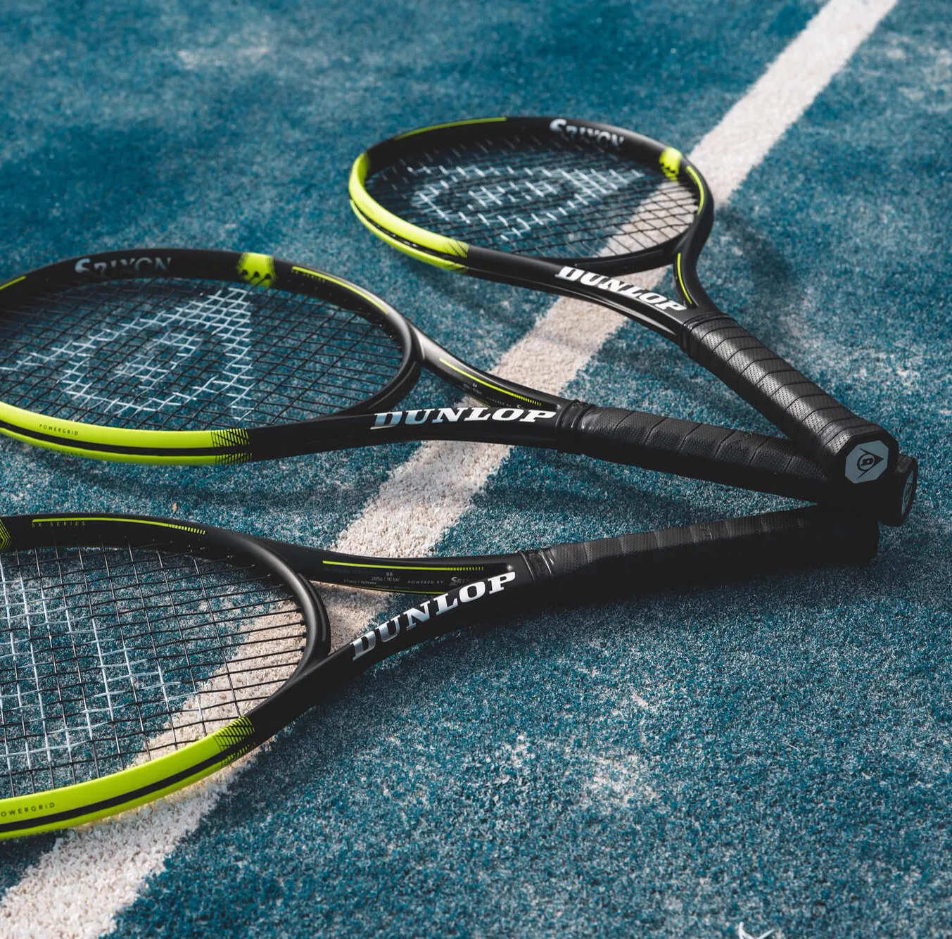 Trois raquettes de tennis posées sur un court
