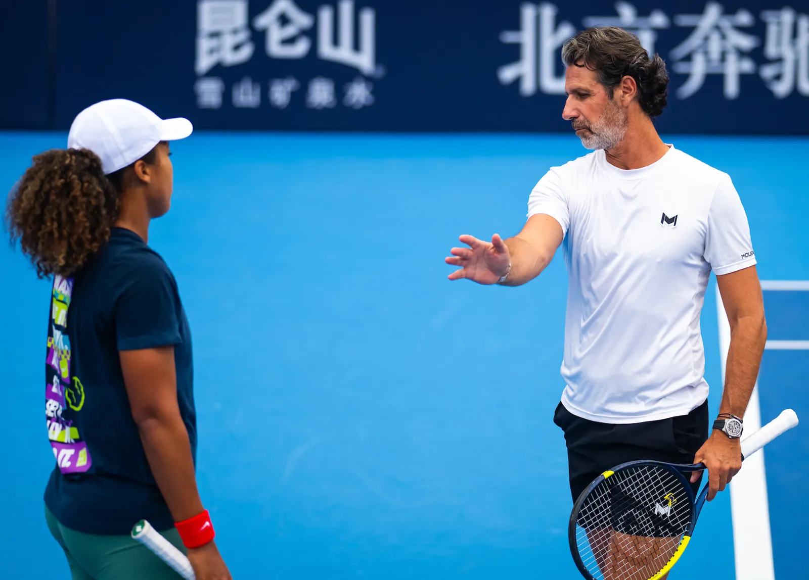 Patrick Mouratoglou donnant une consigne à une joueuse sur un court dur