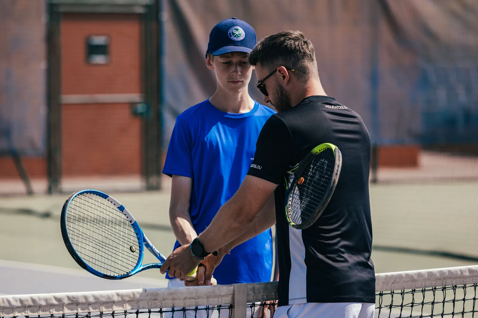 Coach de la Mouratoglou Academy expliquant un geste sur le court