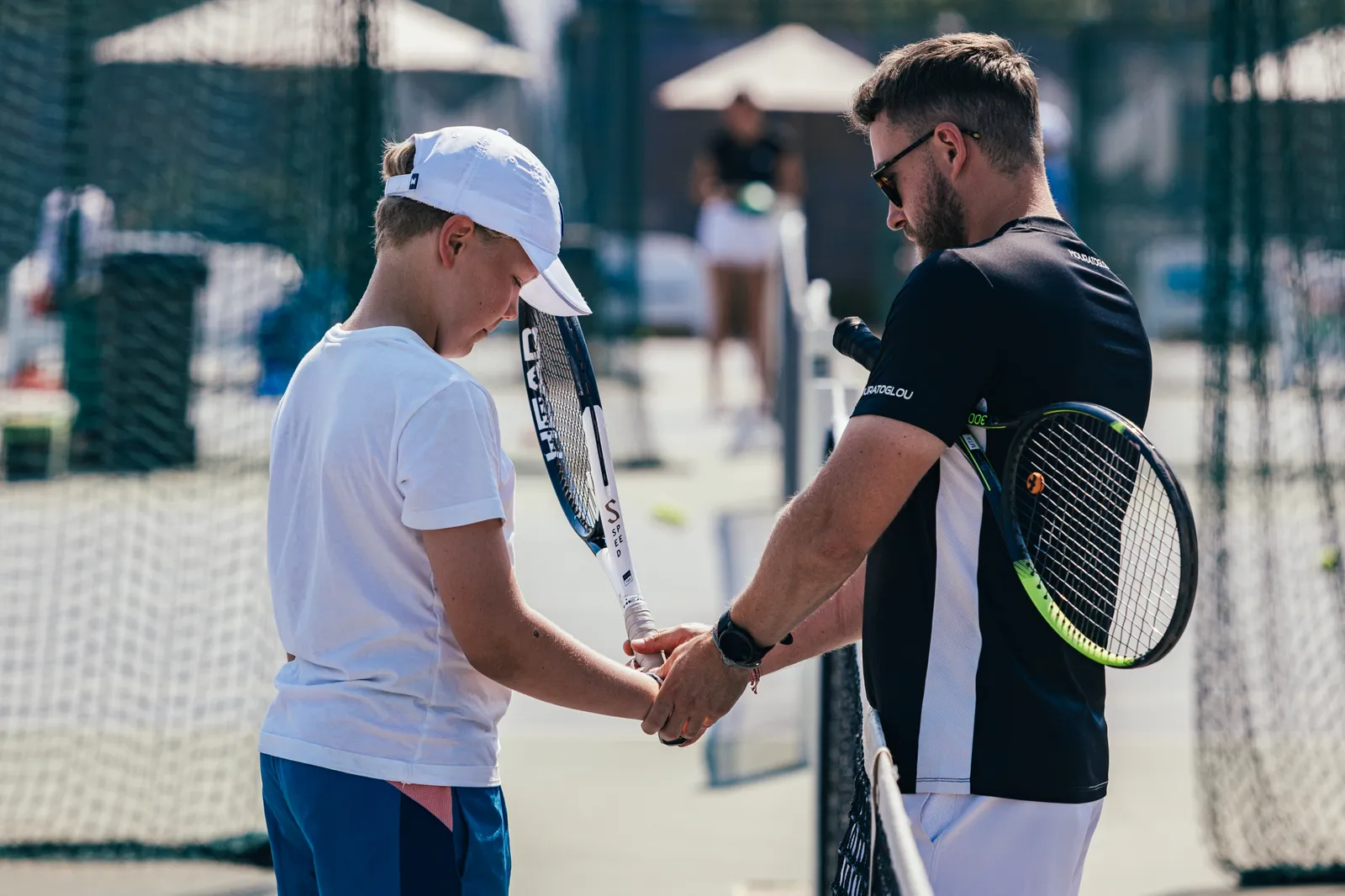 Gros plan sur une main tenant le manche d’une raquette de tennis