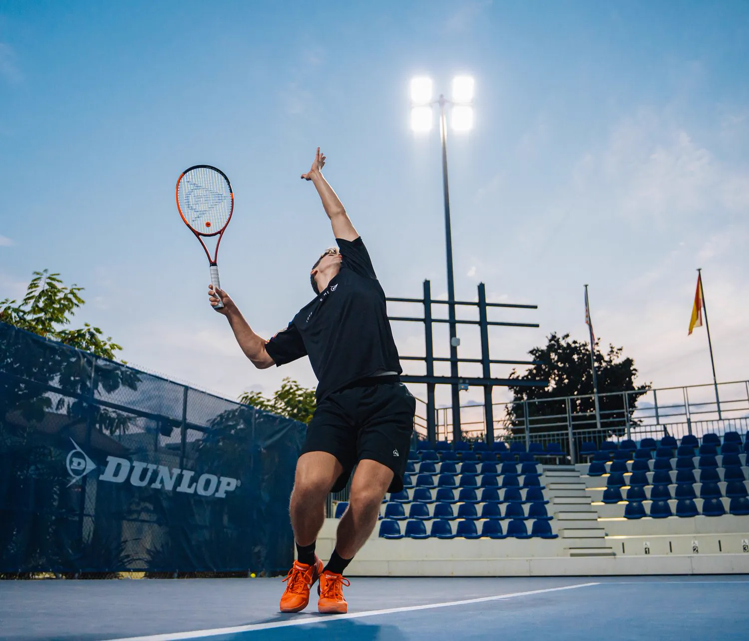 Joueur au service sur un court de la Mouratoglou Academy