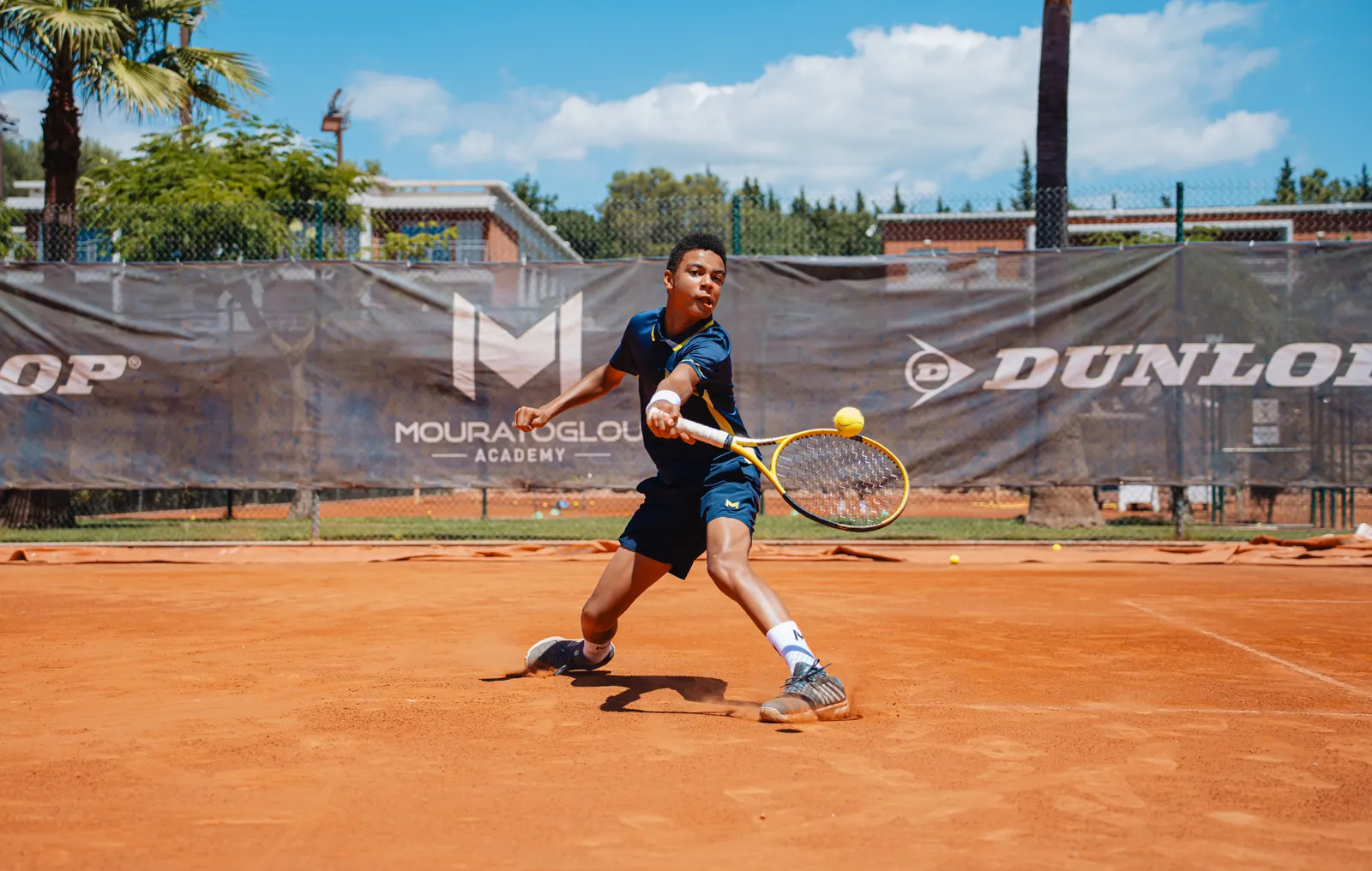 Player playing a drop shot on a clay court