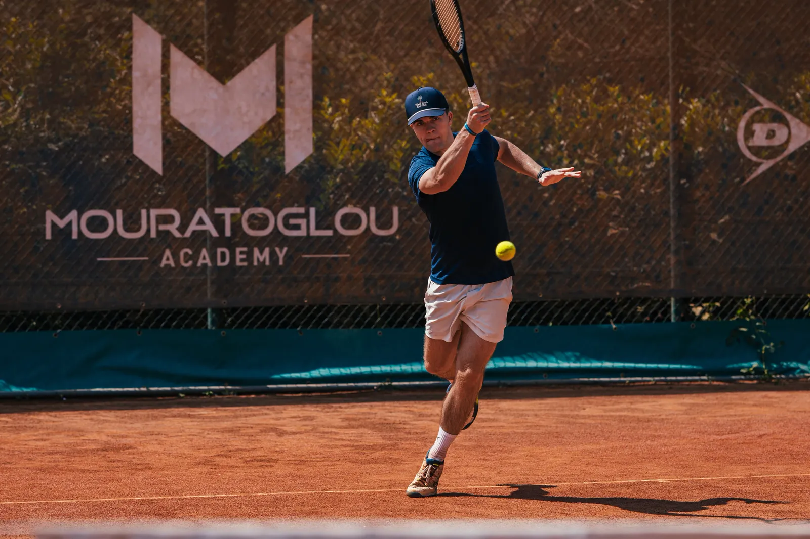 Coach giving a tennis lesson to an adult beginner