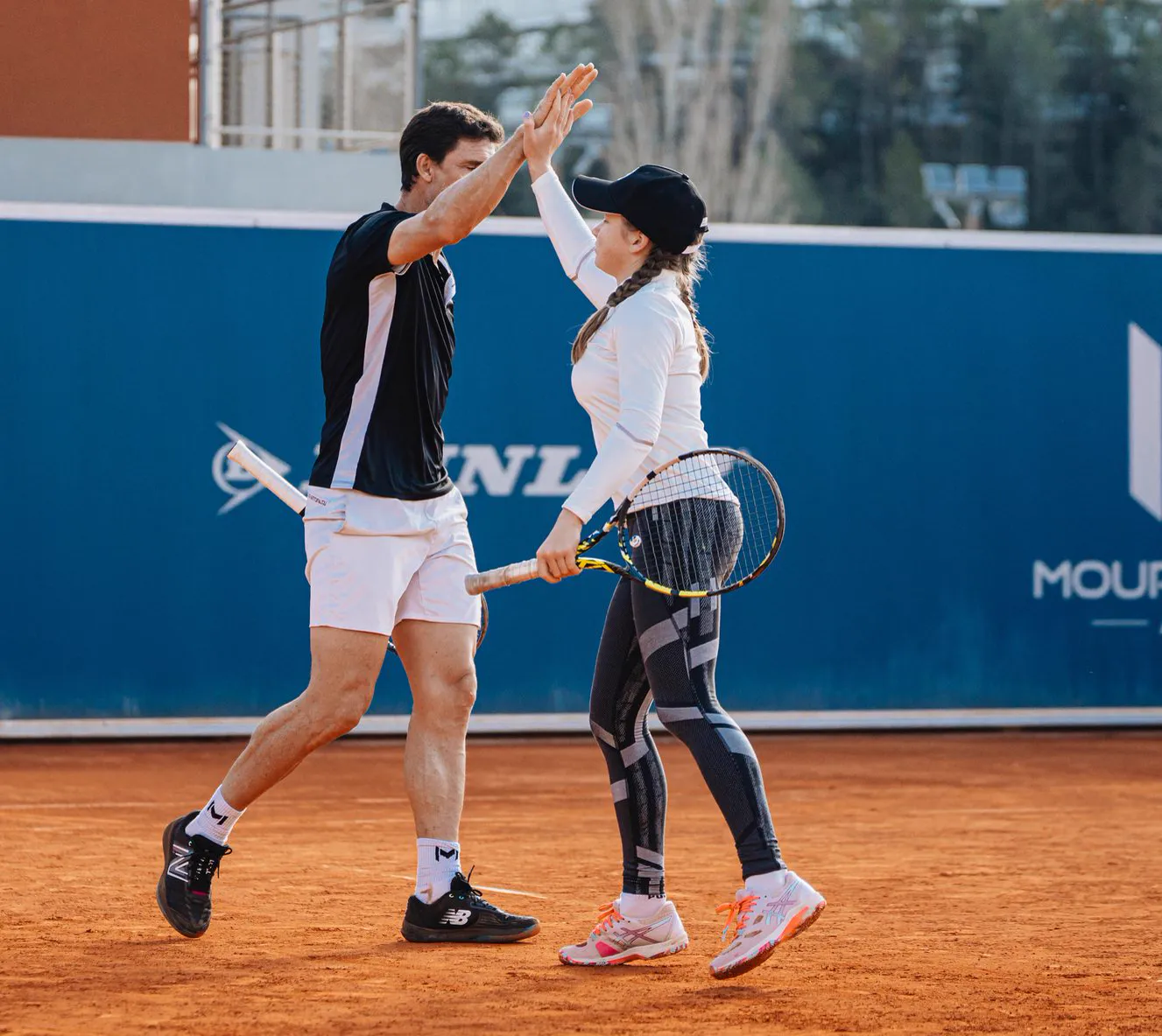 Coach and player giving each other a high five on court