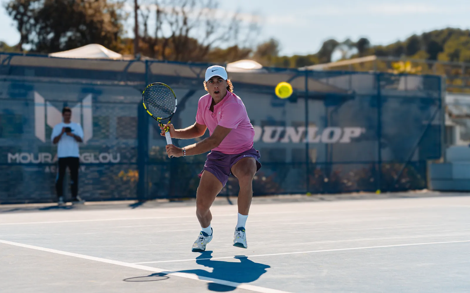 Joueur frappant un revers à l’entraînement sur un court de la Mouratoglou Academy