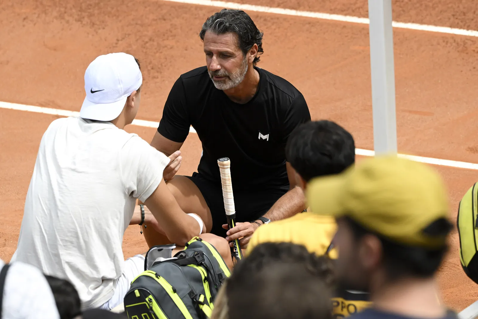 Coach de la Mouratoglou Academy expliquant un schéma tactique à un joueur