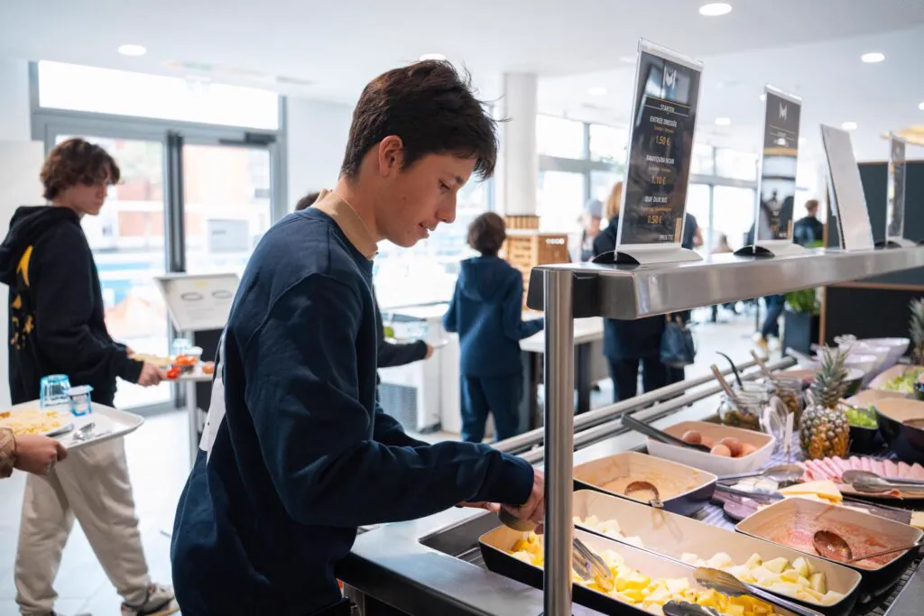 Schüler wählen ihr Mittagessen am Campus-Buffet