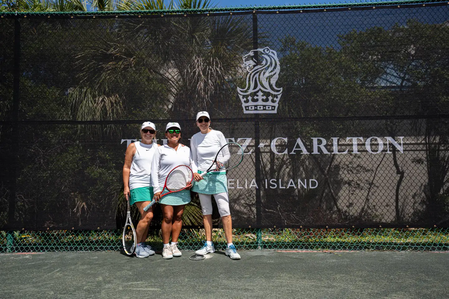 Gruppenfoto vor den Windschutzplanen des Mouratoglou Tennis Center in Amelia Island