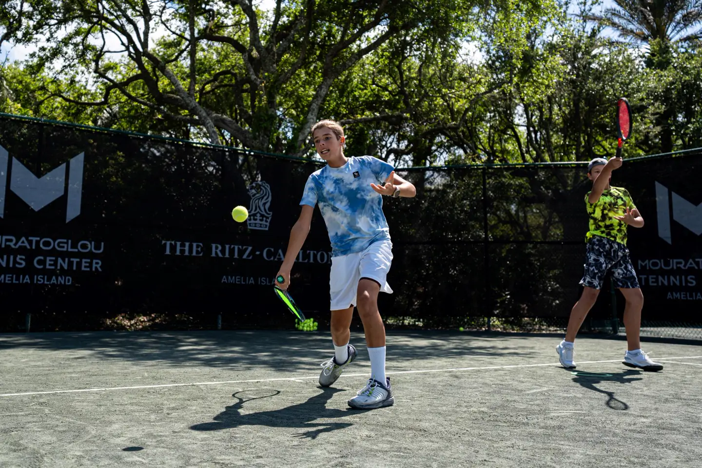 Niño recibiendo una pelota de tenis en las pistas del Mouratoglou Tennis Center Amelia Island