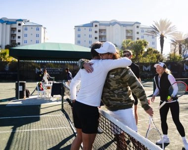 Patrick Mouratoglou saludando a un jugador en las pistas del Mouratoglou Tennis Center Amelia Island.
