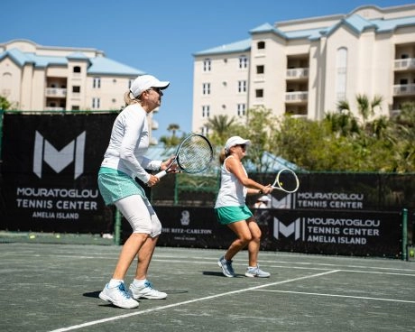 Dos mujeres jugando al tenis durante un clinic en el Mouratoglou Tennis Center Amelia Island