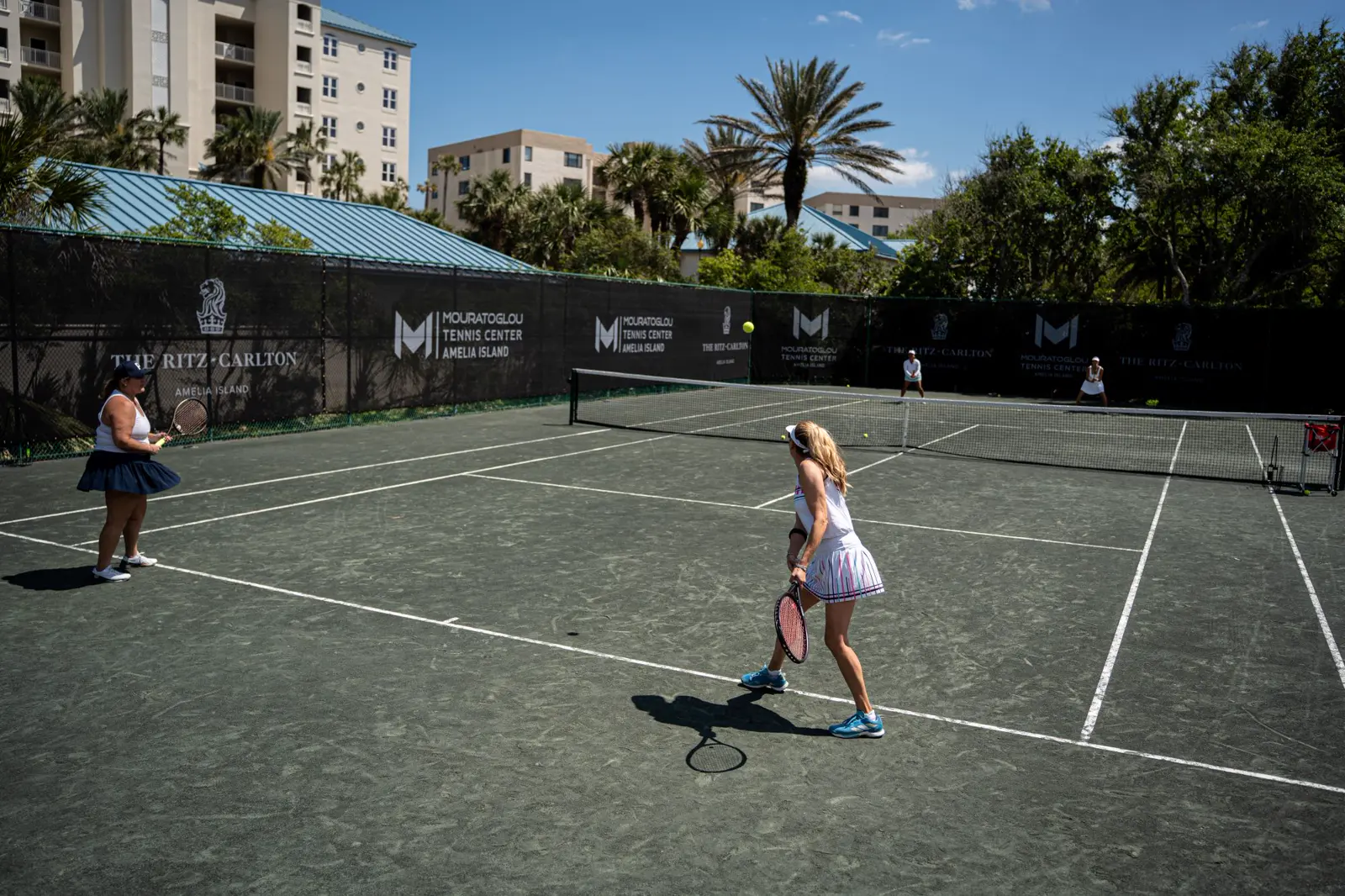 Vier Frauen beim Tennisspielen auf den Plätzen