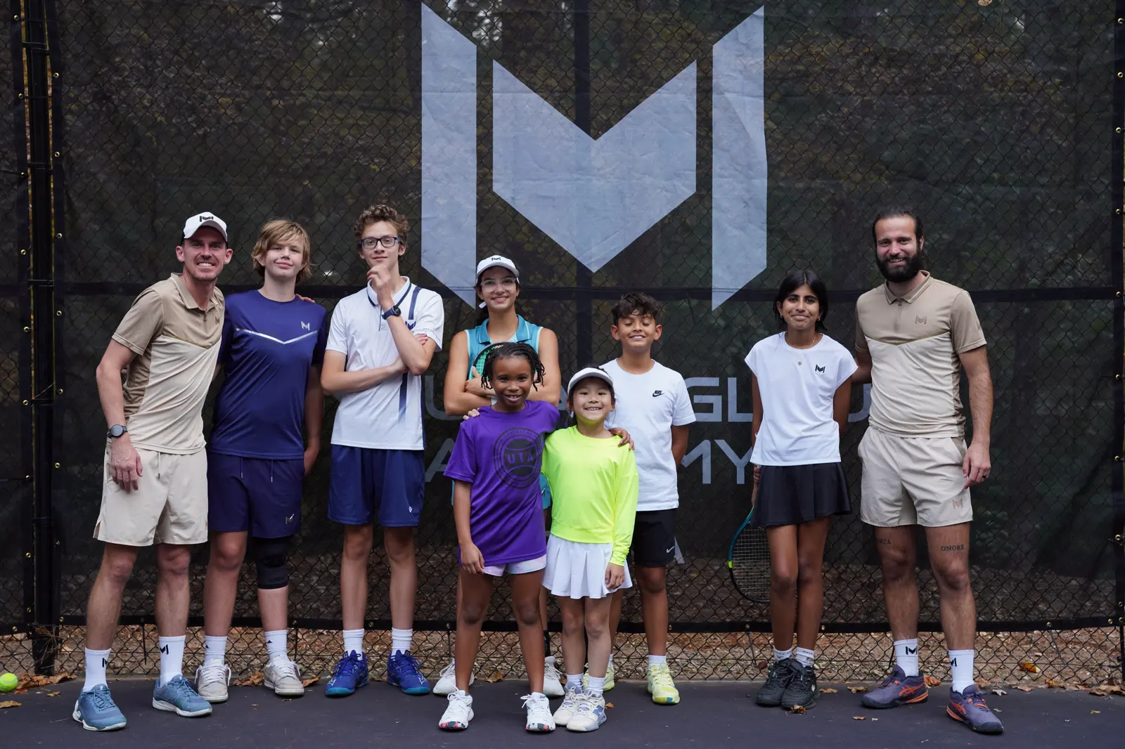 Jugadores de tenis delante de los cortavientos Mouratoglou en la Mouratoglou Academy Atlanta