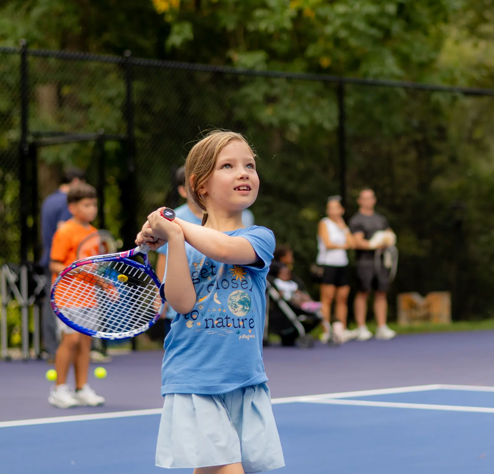 Una niña jugando al tenis en una pista exterior de la Mouratoglou Academy Atlanta