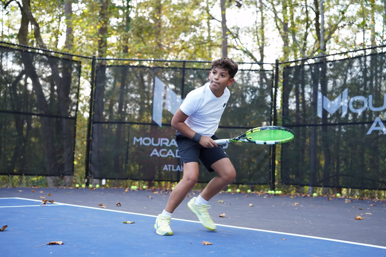 Joven jugador de tenis entrenando en la pista de la Mouratoglou Academy Atlanta