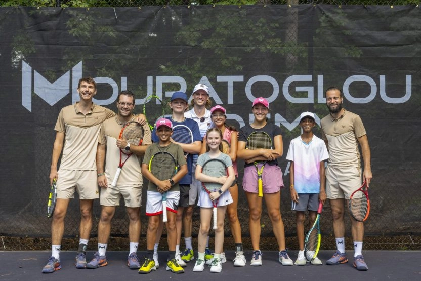 Tennis & Schule-Schüler posieren mit ihren Coaches auf den Plätzen der Mouratoglou Academy Atlanta.