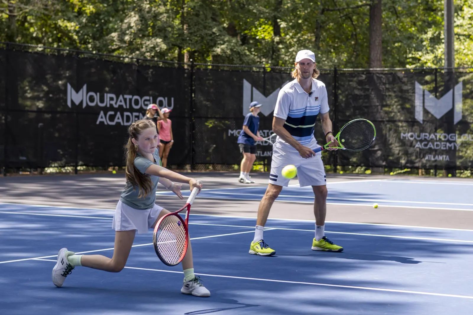 Young tennis player training on court with Andreas Seppi at Mouratoglou Academy Atlanta