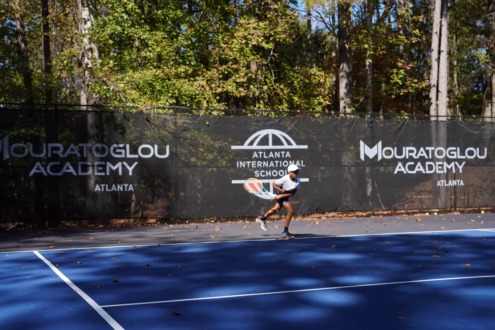 Joven jugador de tenis entrenando en la pista de la Mouratoglou Academy Atlanta