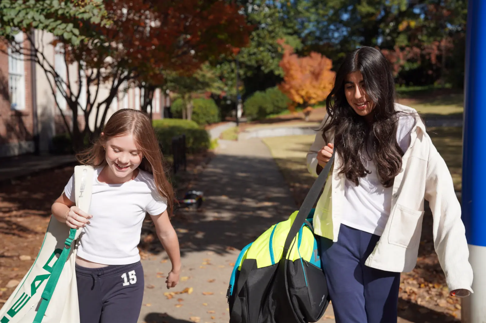 Due giovani tennisti camminano nel campus con le borse da tennis all’Atlanta International School