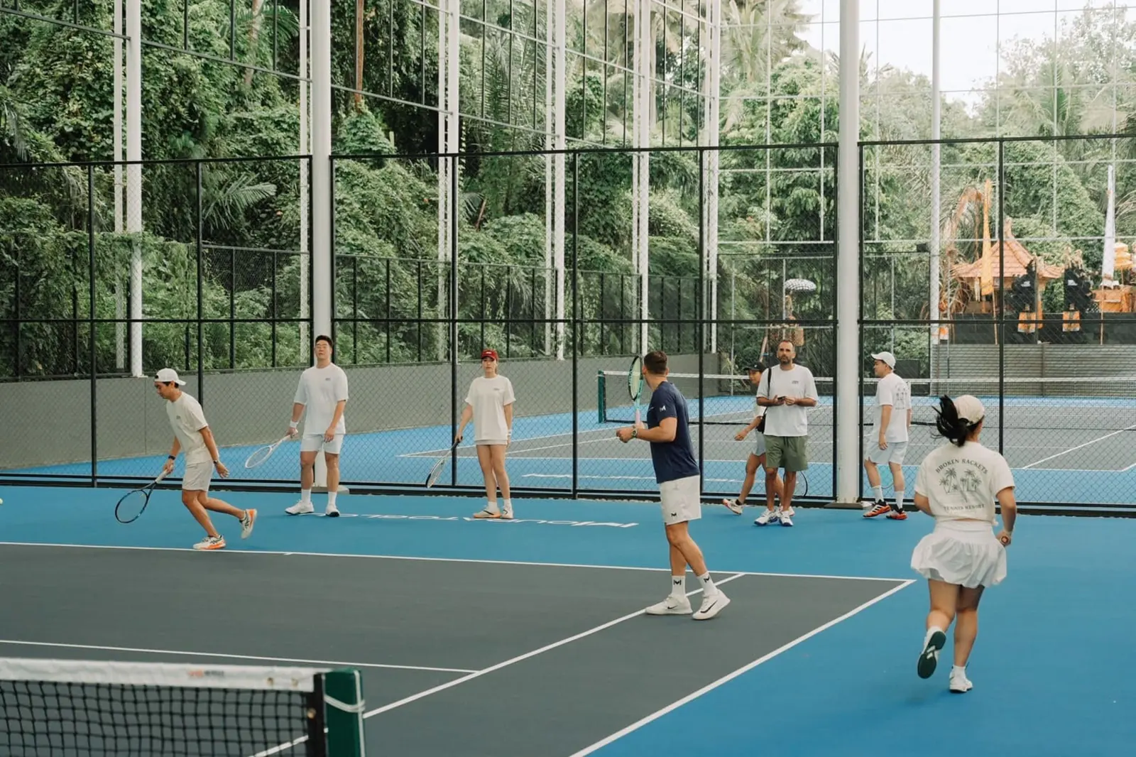 Allenamento di gruppo di un camp per adulti sui campi in cemento semi-coperti del Mouratoglou Tennis Center Bali