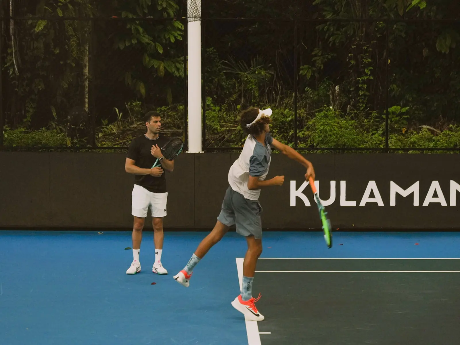 Coach e giocatore si allenano su un campo in cemento al Mouratoglou Tennis Center Bali