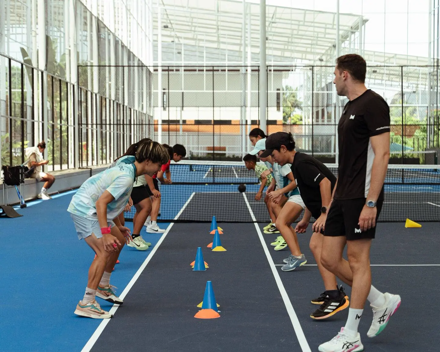 Giovani giocatori durante un esercizio di agilità in un camp junior al Mouratoglou Tennis Center Bali