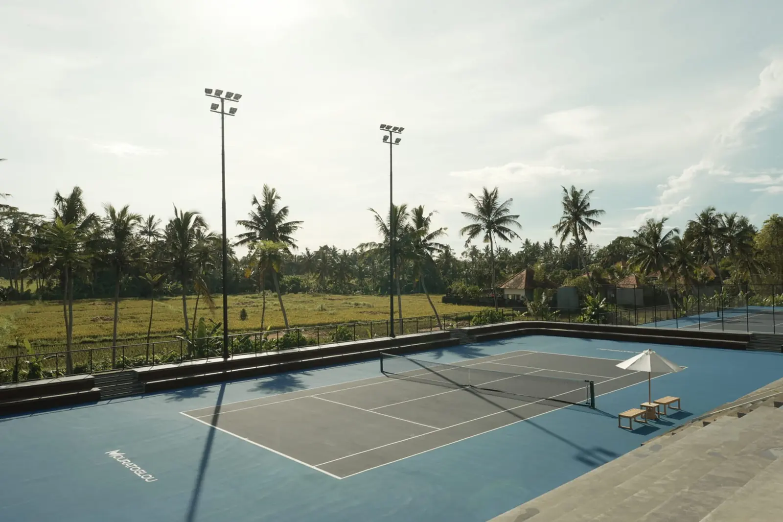 Court de tennis extérieur entouré d’un paysage tropical au Mouratoglou Tennis Center Bali