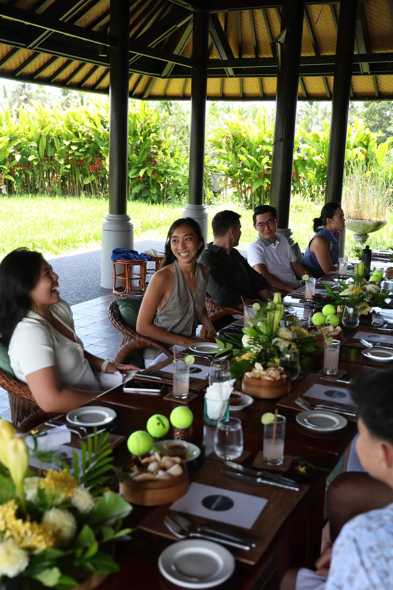Ospiti che condividono un pranzo a una lunga tavolata al Kula Mani, Bali.