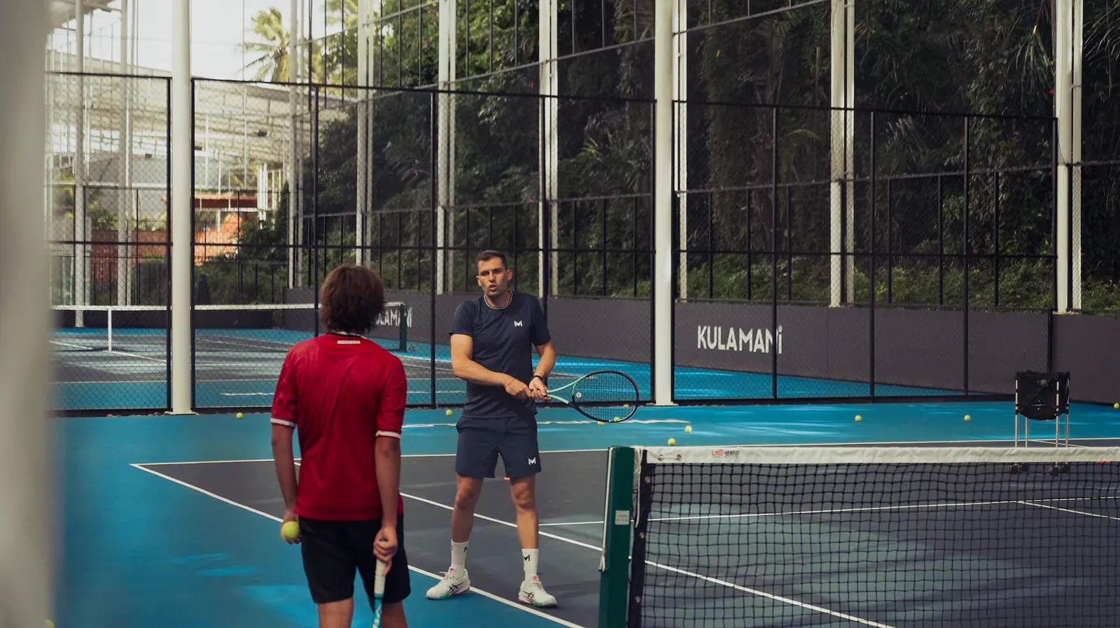 Coach e giocatore sui campi coperti del Mouratoglou Tennis Center Bali.