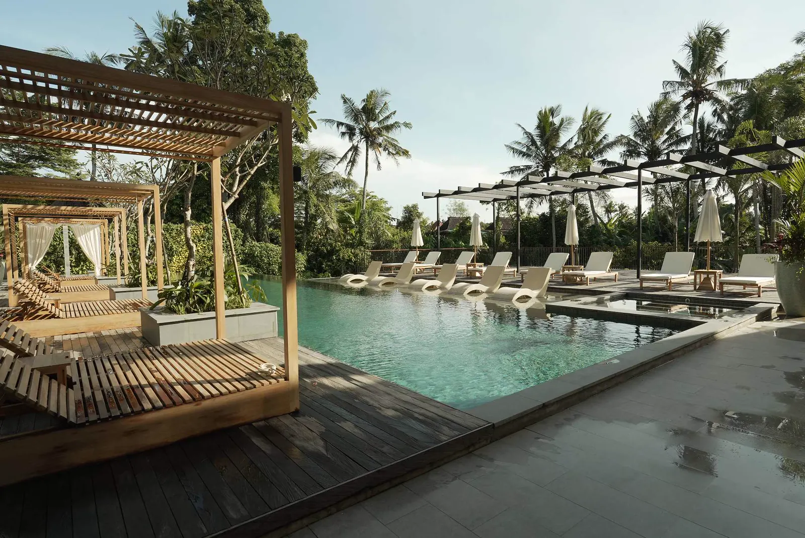 Cabana e lettini a bordo piscina al resort Kula Mani di Bali.