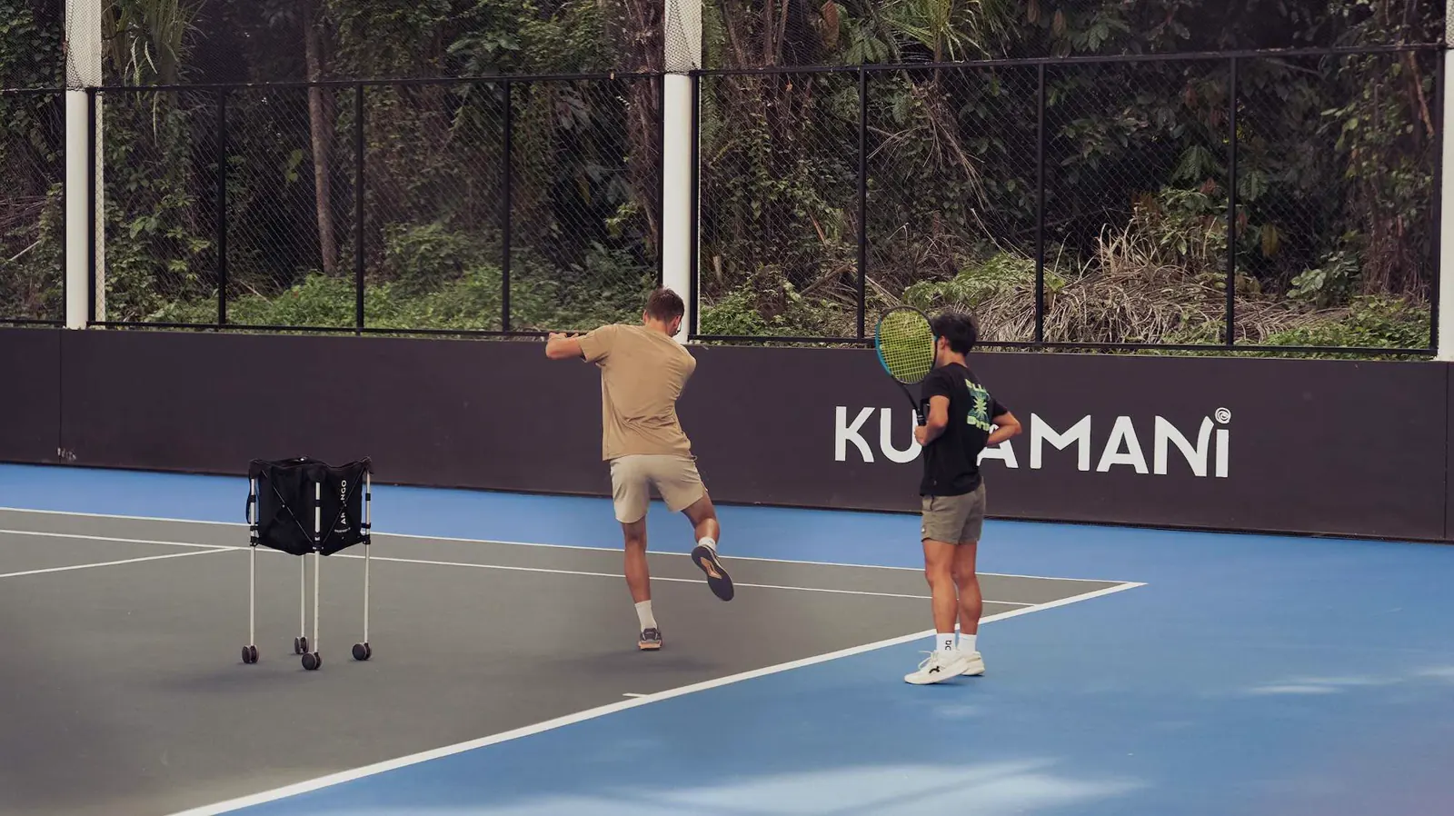 Giocatori che palleggiano davanti al muro del Kula Mani al Mouratoglou Tennis Center Bali.