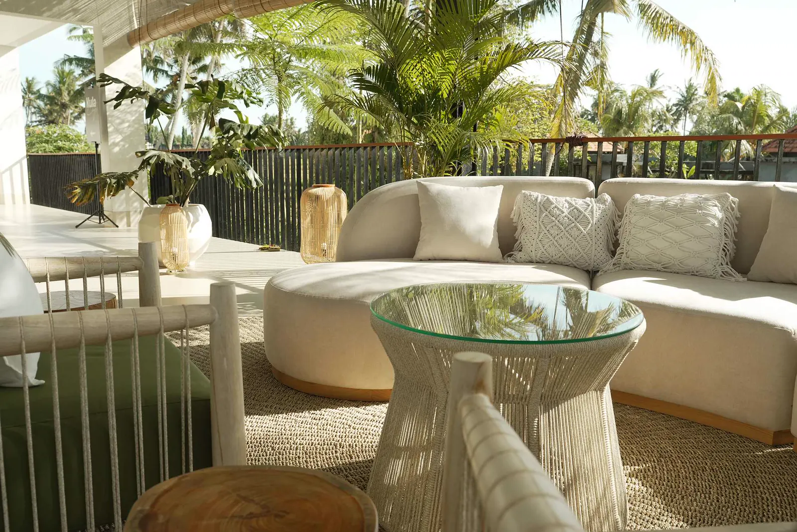 Area lounge con divani bianchi e piante tropicali al Kula Mani, Bali.