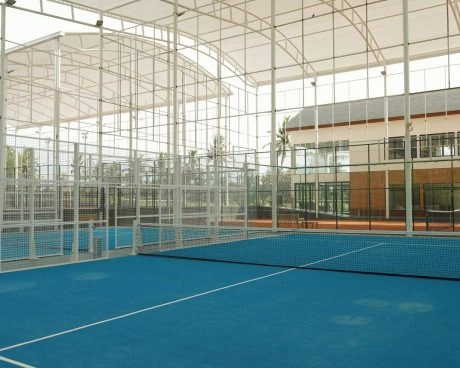 Campo da padel semi-coperto al Mouratoglou Tennis Center Bali, con il paesaggio tropicale visibile all’esterno.