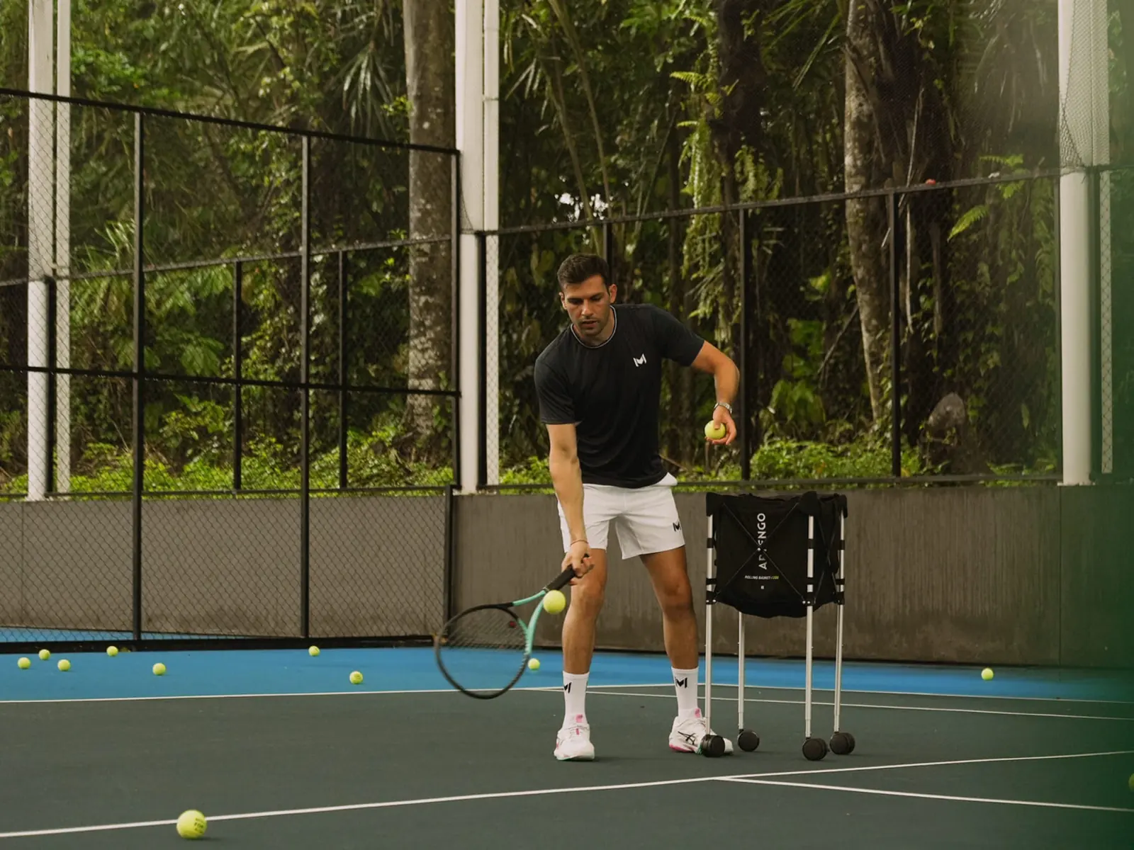 Entrenador y jugador durante una clase de tenis en una pista dura cubierta del Mouratoglou Tennis Center Bali