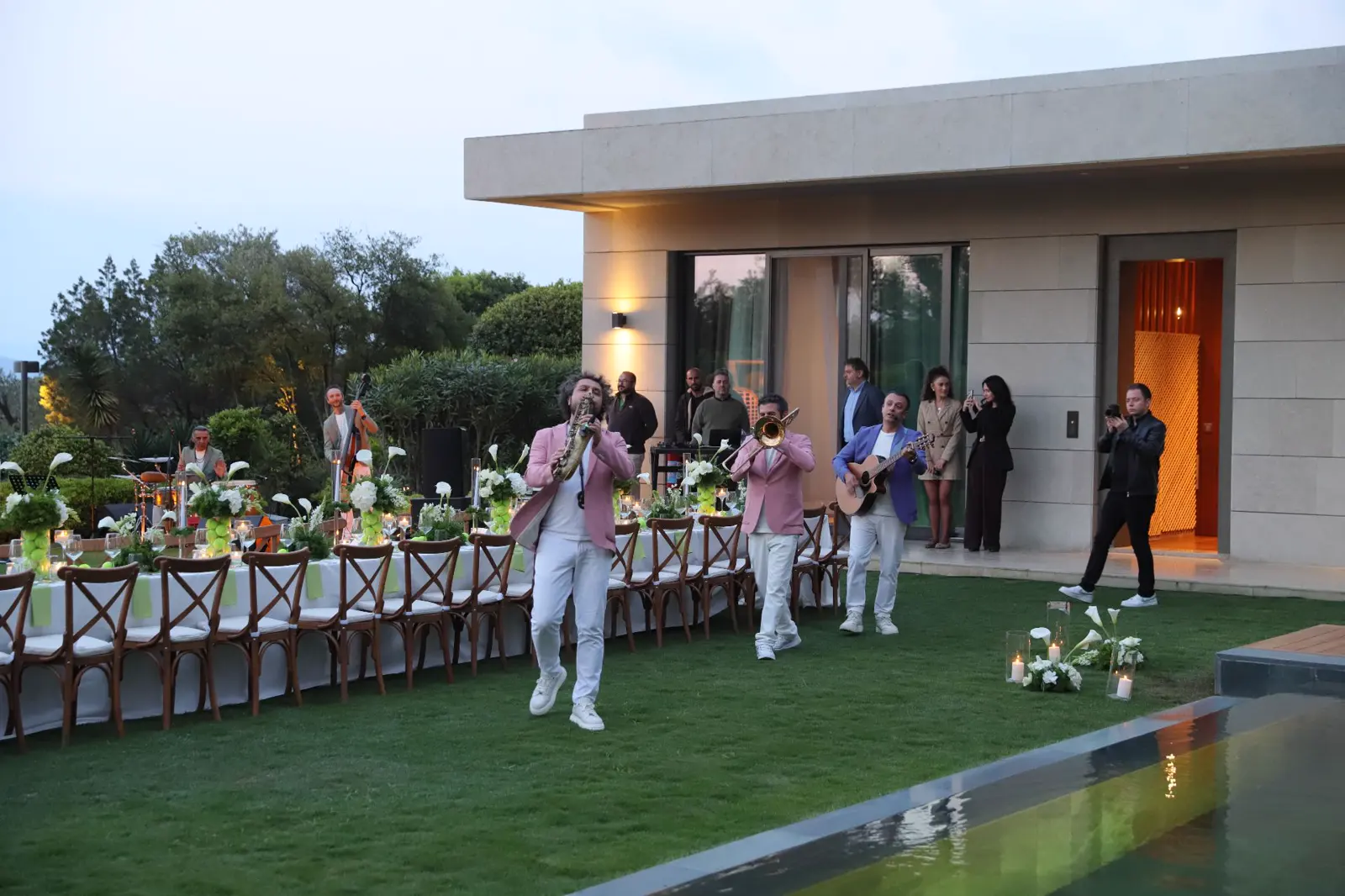 Invitados y músicos en un evento de marca en una terraza ajardinada de Bodrum