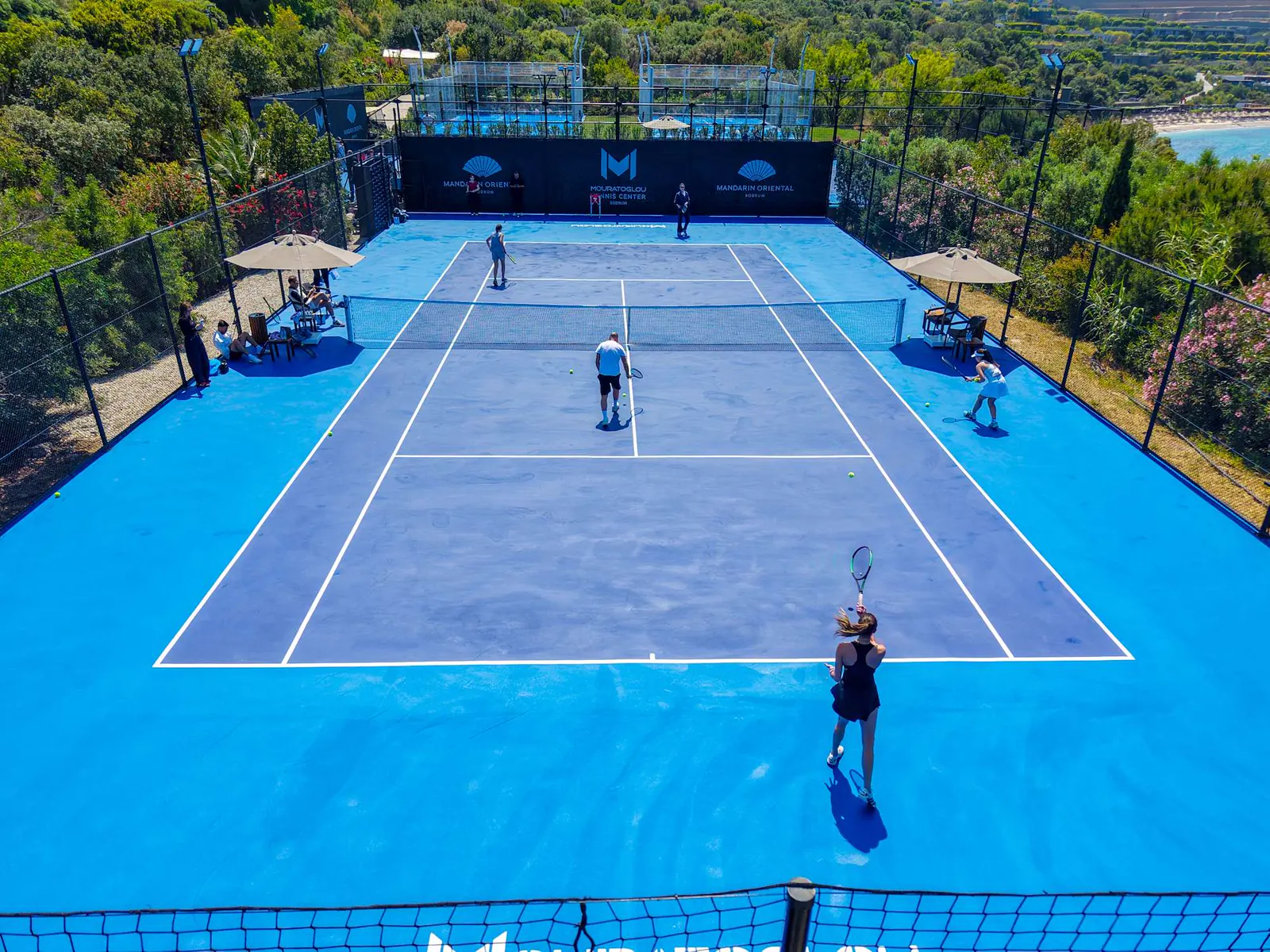 Vista aérea de una pista de tenis azul en el Mouratoglou Tennis Center Bodrum.