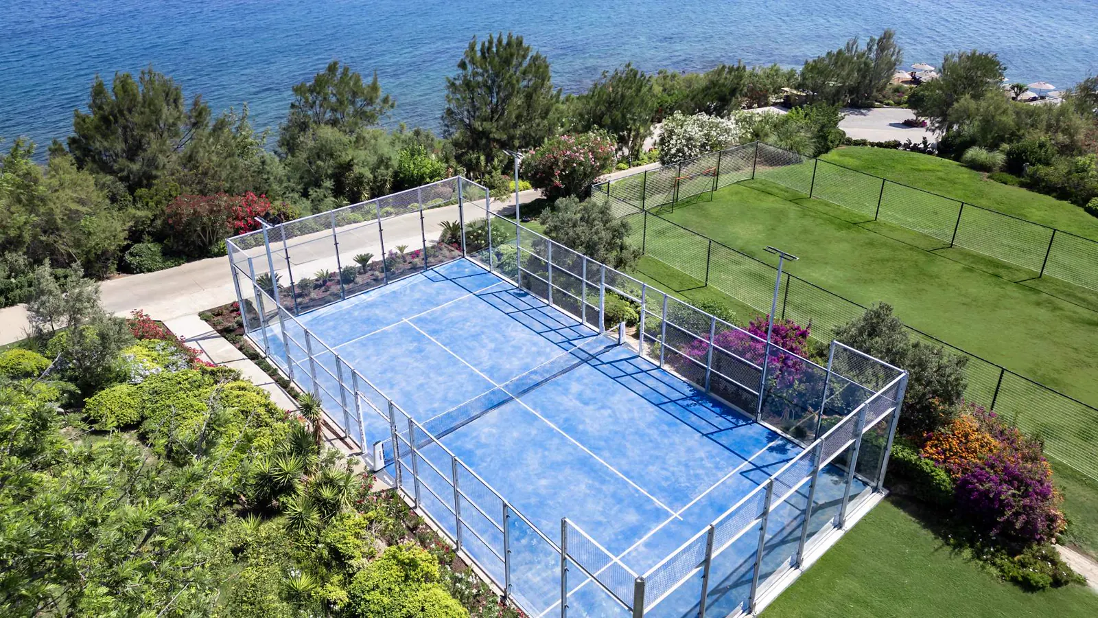 Vista aérea de una pista de pádel rodeada de vegetación en el Mouratoglou Tennis Center Bodrum.
